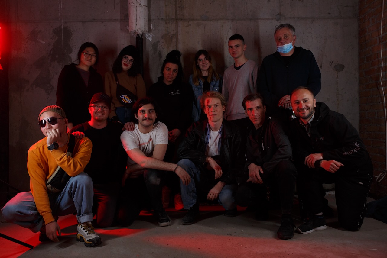 Cast and crew grouped for a photograph on the Adok set.