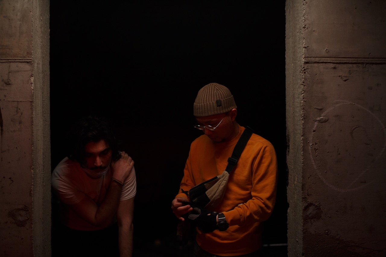 Two crew members in a concrete doorway.
