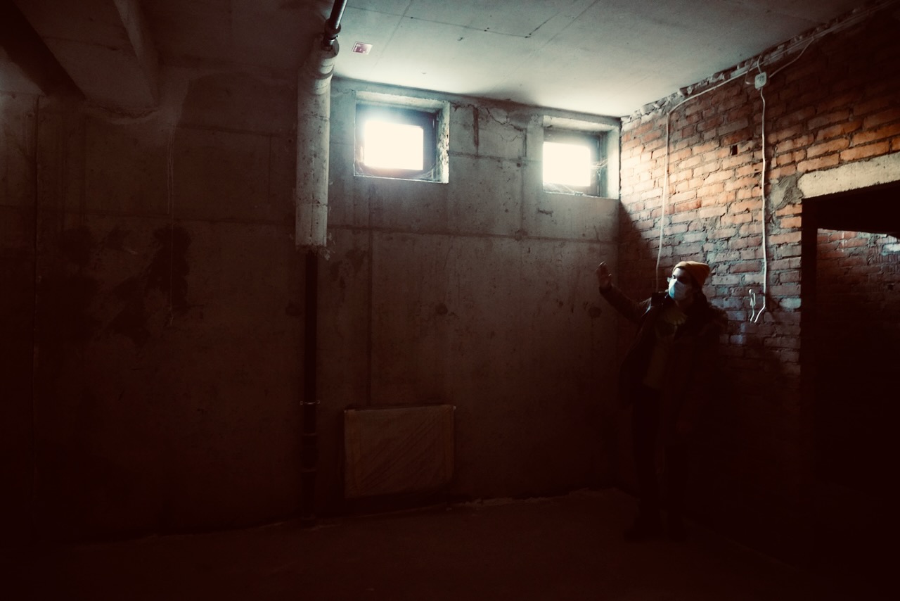 An empty concrete room during a location visit.